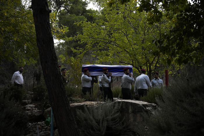 Soldados israelíes cargan un féretro cubierto con la bandera de Israel en el que yace el mayor Tal Cohen durante su funeral en el cementerio Givat Shaul, el martes 10 de octubre de 2023, en Jerusalén. La más reciente guerra entre Israel y los palestinos resonó en todo el mundo el martes, mientras gobiernos extranjeros intentaban determinar cuántos de sus ciudadanos habían muerto, estaban desaparecidos o necesitaban de asistencia médica o de vuelos para volver a casa.