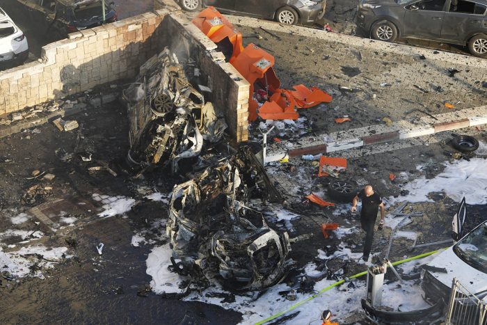 Soldados israelíes sofocan un incendio provocado por el impacto de un proyectil disparado desde la Franja de Gaza en un estacionamiento en Ashkelon, en el sur de Israel, el 7 de octubre de 2023.