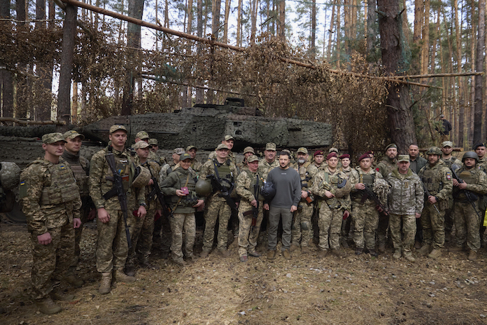 En esta imagen, distribuida por la oficina de prensa de la presidencia de Ucrania, el Presidente, Volodímir Zelenski (centro), posa para una foto con soldados delante de un tanque Leopard 2, en la línea del frente en al región de Járkiv, Ucrania, el 3 de octubre de 2023.