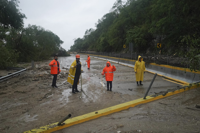 Trabajadores limpian una carretera bloqueada tras el paso del huracán "Otis" cerca de Acapulco, México, el miércoles 25 de octubre de 2023.