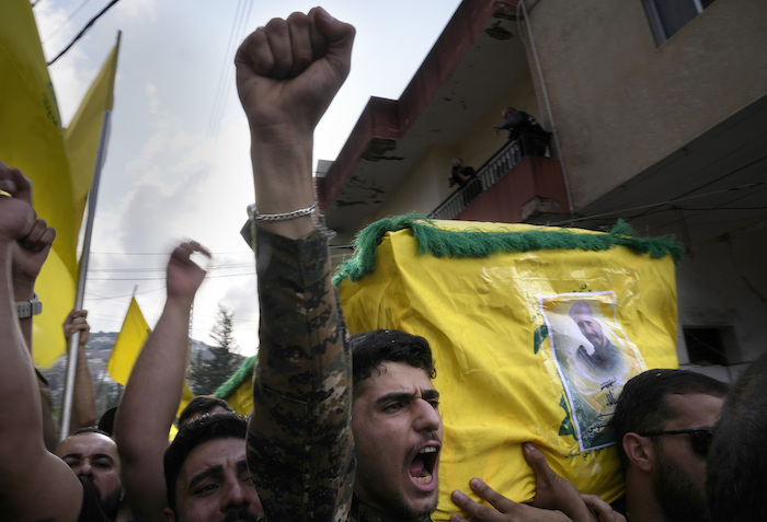 Un combatiente de Hezbollah carga el ataúd de uno de sus compañeros que murió por artillería israelí, mientras grita consignas durante una procesión fúnebre, el martes 10 de octubre de 2023, en el poblado de Khirbet Selm, en el sur de Líbano. El grupo respaldado por Irán anunció el lunes por la noche que tres de sus elementos murieron luego de un intenso bombardeo israelí contra distintos poblados en el sur de Líbano.