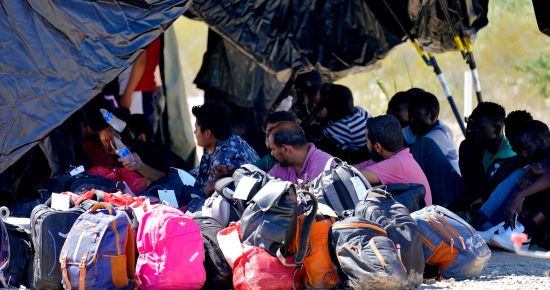 Un grupo de hombres detenidos por la Oficina de Aduanas y Patrulla Fronteriza de Estados Unidos tras cruzar el muro fronterizo en el sector de Tucson entre México y Estados Unidos son procesados en un centro improvisado el martes 29 de agosto de 2023.