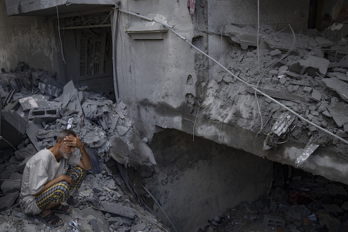 Un hombre sentado afuera del edificio donde vivía que fue destruido durante unos ataques israelíes en el campamento de refugiados de Rafah, en la Franja de Gaza, el martes 17 de octubre de 2023.