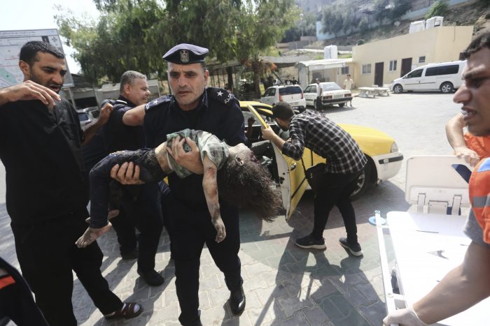 Un policía de Hamás llega con una niña herida a un hospital en Beit Lahiya, en la Franja de Gaza, el domingo 8 de octubre de 2023.