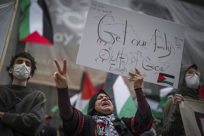 Una manifestante propalestina sostiene un cartel y corea durante una manifestación en Vancouver, en la Columbia Británica, el lunes 9 de octubre de 2023. El cartel dice "Saquen a nuestra familia de Gaza. Basta. ¡Mi hermana perdió su casa! Ahora mi familia vive en carpas".