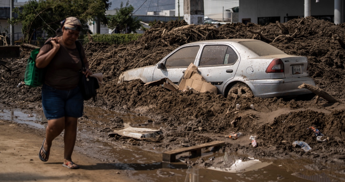 Una mujer camina por una zona dañada tras el paso del huracán "Otis", el domingo 29 de octubre de 2023, en Acapulco, México.