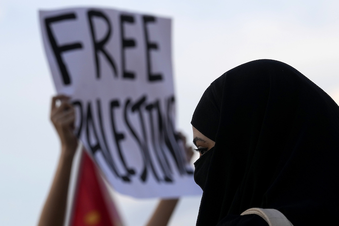 Una mujer de la comunidad palestina participa en una protesta en apoyo del pueblo palestino ante el Museo Nacional de Brasilia, Brasil, el martes 10 de octubre de 2023. El cartel dice "Liberen a Palestina".