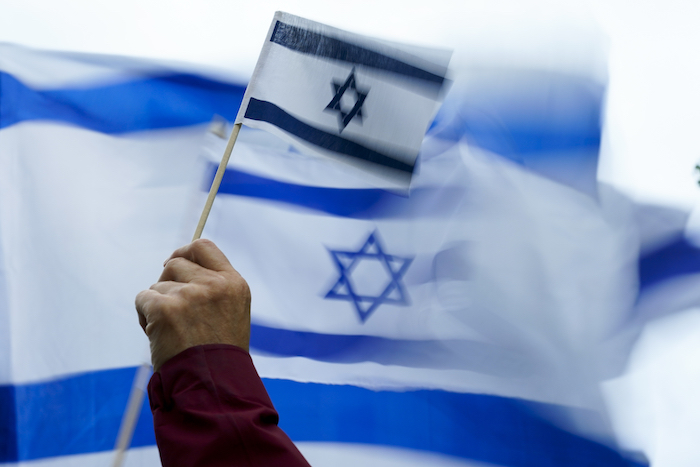 Una persona sostiene una bandera de Israel durante una manifestación el lunes 9 de octubre de 2023 en Bellevue, Washington. 