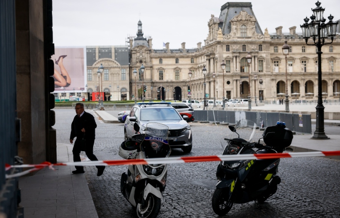 Vehículos de la policía mientras agentes vigilan afuera del Museo del Louvre, durante una evacuación luego de que recibieron una amenaza de bomba escrita, en París, el sábado 14 de octubre de 2023.