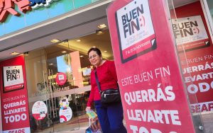 Una mujer sale de una tienda departamental durante las ofertas del Buen Fin.