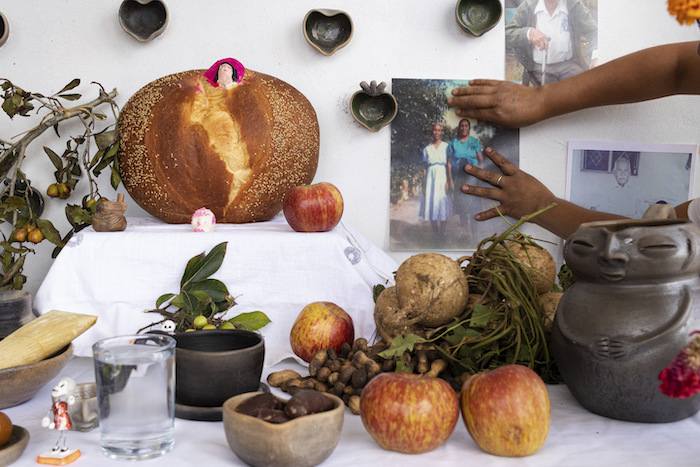 Ana Martínez coloca una foto en su altar del Día de Muertos en la terraza de su casa en Santa María Atzompa, México, el martes 31 de octubre de 2023.