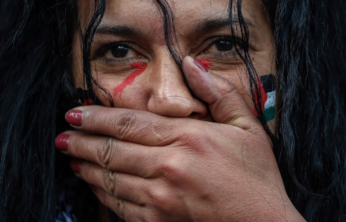 Una manifestante participa en un minuto de silencio durante una manifestación organizada por el "Colectivo nacional para una paz justa y duradera entre palestinos e israelíes" en París, el domingo 22 de octubre de 2023. 