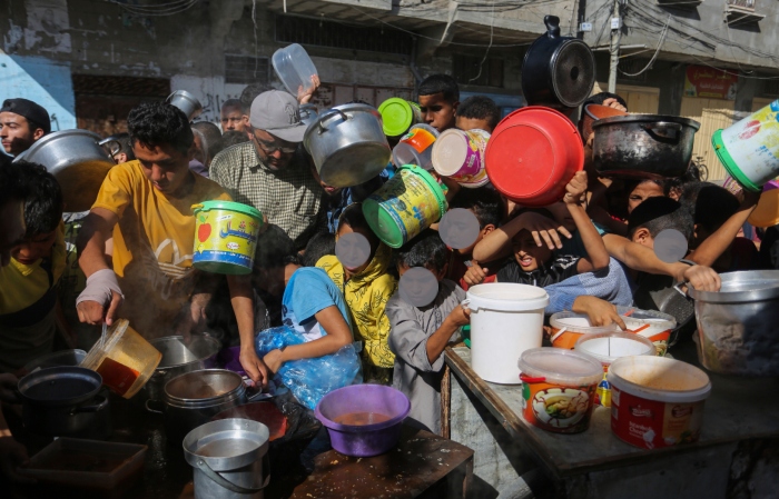 Palestinos se agolpan para recibir comida en Rafah, en el sur de la Franja de Gaza.