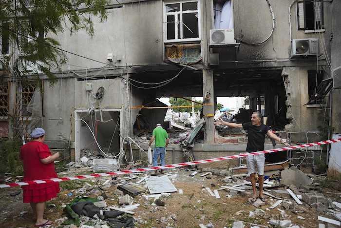 Israelíes inspeccionan un edificio residencial dañado tras recibir el impacto de un proyectil disparado desde la Franja de Gaza, en Ashkelon, Israel, el 9 de octubre de 2023.