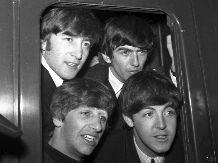 La banda británica The Beatles, en el orden de las manecillas del reloj, John Lennon, George Harrison, Paul McCartney y Ringo Starr, posan en la ventanilla de un tren antes de partir de Paddington Station en Londres, el 2 de marzo de 1964. La última canción de los Beatles con John, Paul, George y Ringo titulada "Now and Then" fue lanzada el 2 de noviembre de 2023 gracias al uso de inteligencia artificial.