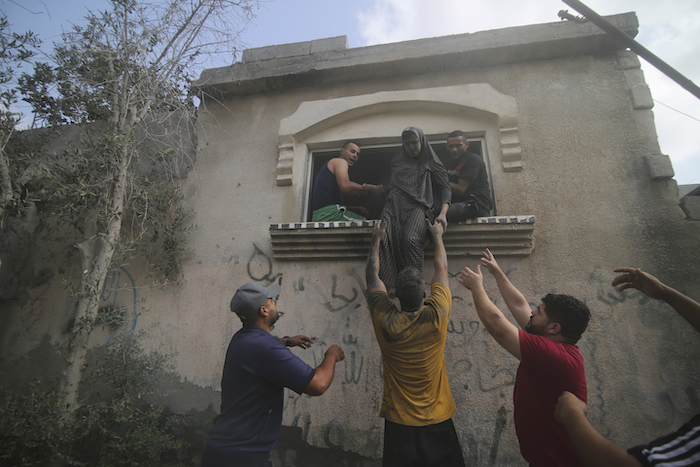 Palestinos desalojan un edificio alcanzado por un bombardeo aéreo israelí sobre la Franja de Gaza, en Rafah, el 22 de octubre de 2023.