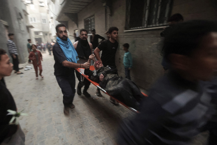 Palestinos evacúan a una mujer herida tras un ataque aéreo israelí en el campo de refugiados de Jan Yunis, en el sur de la Franja de Gaza, el lunes 13 de noviembre de 2023.