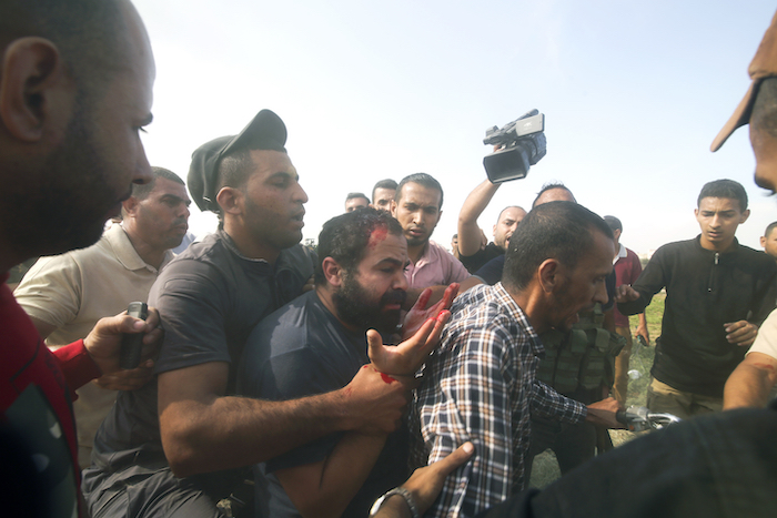 Palestinos llevan a un ciudadano israelí capturado (centro), desde el kibutz de Kfar Azza a la Franja de Gaza, el 7 de octubre de 2023.