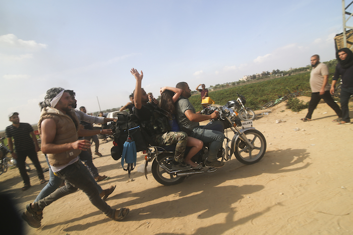 Palestinos llevan a una civil israelí capturada (centro), desde el kibutz de Kfar Azza a la Franja de Gaza, el 7 de octubre de 2023.