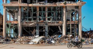 Palestinos pasan en motocicleta junto a un edificio destruido en Ciudad de Gaza el miércoles 29 de noviembre de 2023, en el sexto día del cese al fuego temporal entre Israel y Hamás.