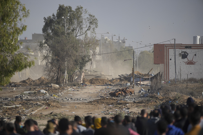 Palestinos tratan de regresar al norte de la Franja de Gaza mientras un tanque israelí bloquea la carretera Salah al-Din en el centro del enclave, el 24 de noviembre de 2023, en las primeras horas de un alto el fuego temporal.