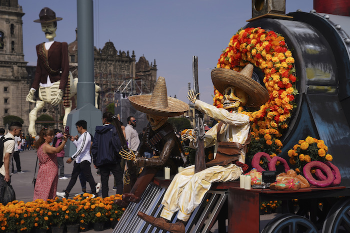 Personas toman fotos de una exhibición por el Día de Muertos en el Zócalo, la principal plaza de Ciudad de México, el martes 31 de octubre de 2023.