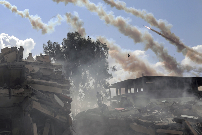 Proyectiles disparados desde la Franja de Gaza hacia Israel pasan sobre edificio destruidos por los ataques aéreos israelíes sobre la Ciudad de Gaza, en el centro del enclave palestino, el 19 de octubre de 2023.