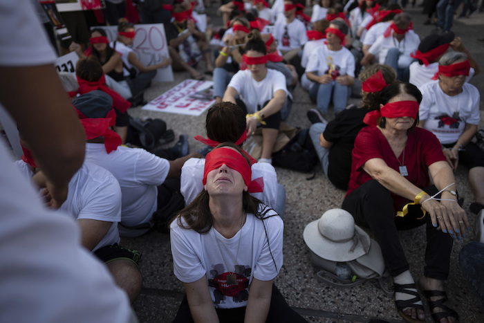 Residentes del kibbutz de Kfar Azza se cubren los ojos y se atan las manos durante una manifestación en solidaridad con sus amigos y familiares retenidos en la Franja de Gaza, en Tel Aviv, Israel, el 2 de noviembre de 2023. Insurgentes de Hamás asaltaron la pequeña comunidad agrícola durante su sangriento ataque transfronterizo desde la Franja el 7 de octubre. Dieciocho residentes fueron secuestrados y llevados al enclave palestino, incluyendo siete menores, el más pequeño de apenas tres años.