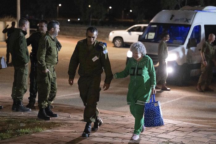 Ruth Munder, una rehén israelí liberada, camina junto a un soldado israelí poco después de su llegada a Israel el viernes 24 de noviembre de 2023.