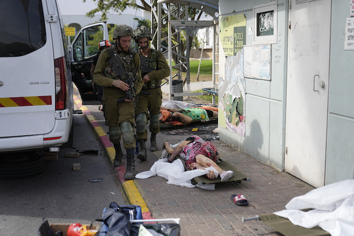 Soldados israelíes pasan junto a civiles asesinados por insurgentes de Hamás en Sderot, Israel, el 7 de octubre de 2023.