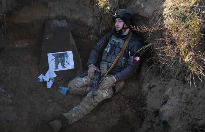 Un soldado de la primera brigada Bureviy (Huracán) de la Guardia Nacional de Ucrania, sentado en una trinchera durante una formación de combate, en un centro de entrenamiento en el norte de Ucrania, el 3 de noviembre de 2023. 