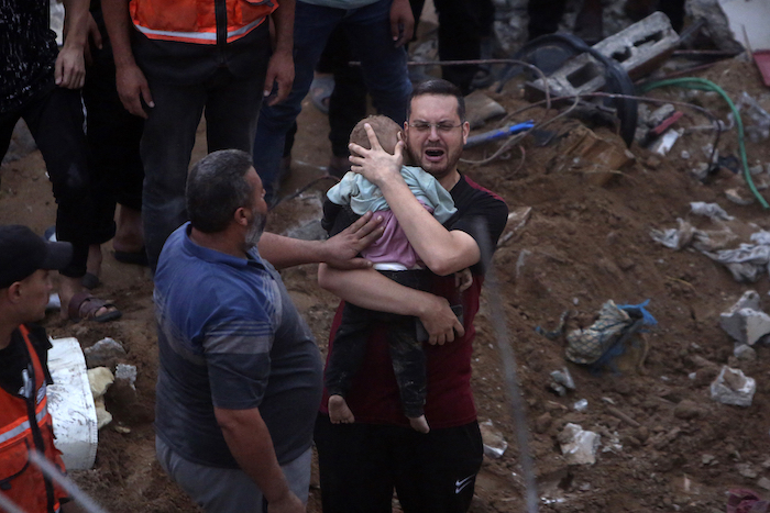 Un hombre palestino llora mientras sostiene en brazos a un bebé muerto encontrado bajo los escombros de un edificio destruido tras ataques aéreos israelíes al campo de refugiados de Nusseirat, en el centro de la Franja de Gaza, el 31 de octubre de 2023.