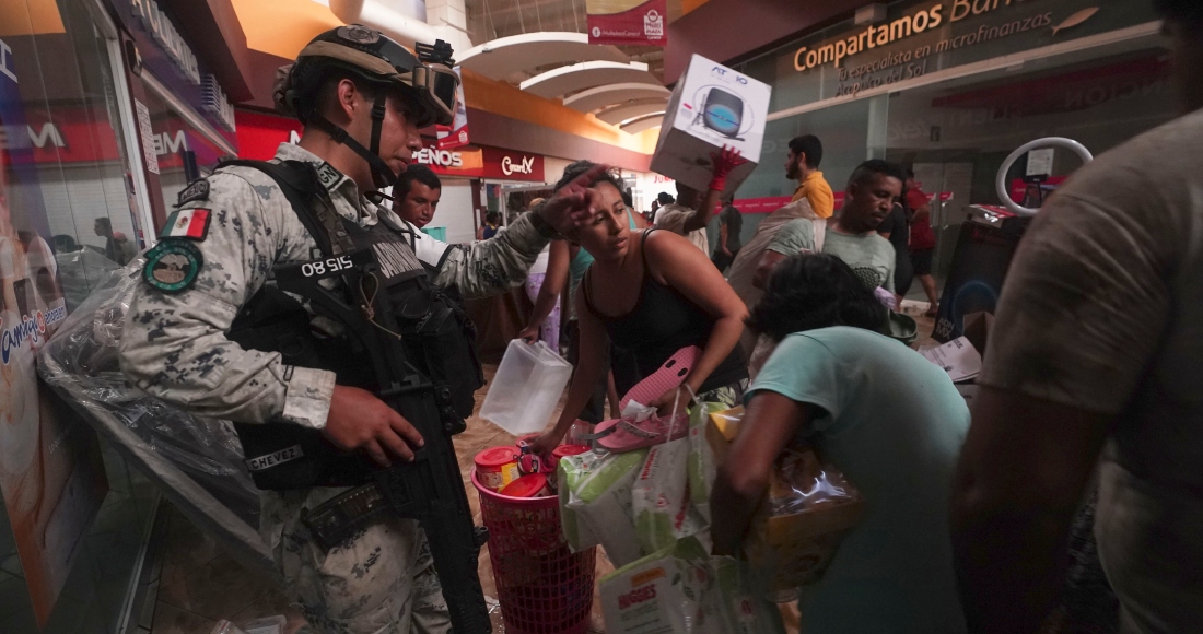 Un militar de la Guardia Nacional mexicana intenta impedir que personas se lleven productos de las tiendas de un centro comercial tras el devastador paso del huracán "Otis" por Acapulco, México, el miércoles 25 de octubre de 2023.