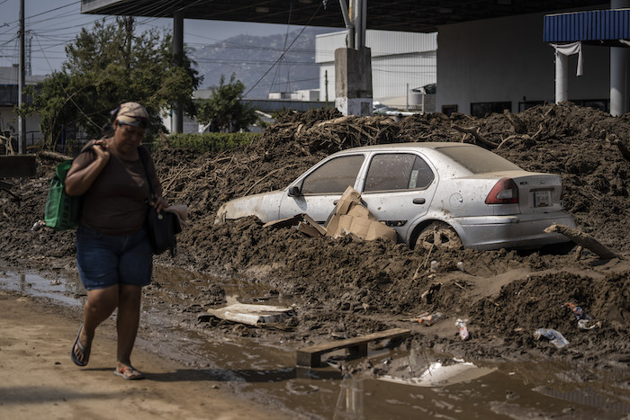 Una mujer camina por una zona dañada tras el paso del huracán "Otis", el domingo 29 de octubre de 2023, en Acapulco, México.