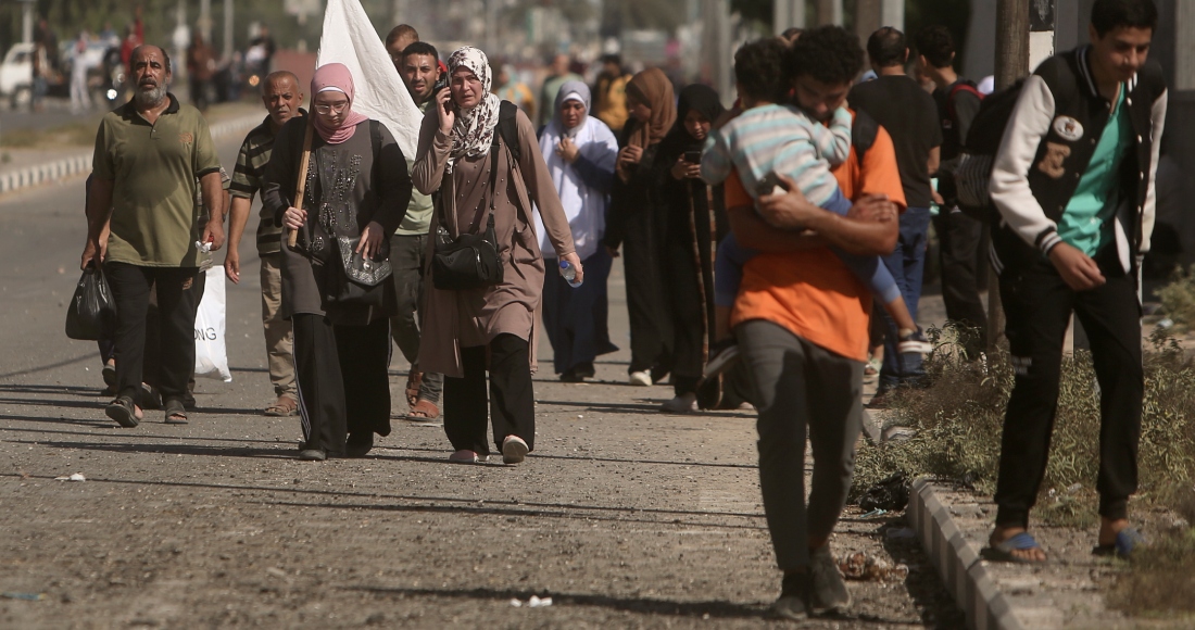 Una mujer carga con una bandera blanca para evitar recibir disparos mientras palestinos huyen de la Ciudad de Gaza hacia el sur de la Franja, en la calle Salah al-Din, en Bureij, el 7 de noviembre de 2023.