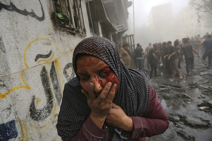 Una mujer palestina herida sale corriendo tras ataques aéreos israelíes sobre su vecindario en la Ciudad de Gaza, el 23 de octubre de 2023.