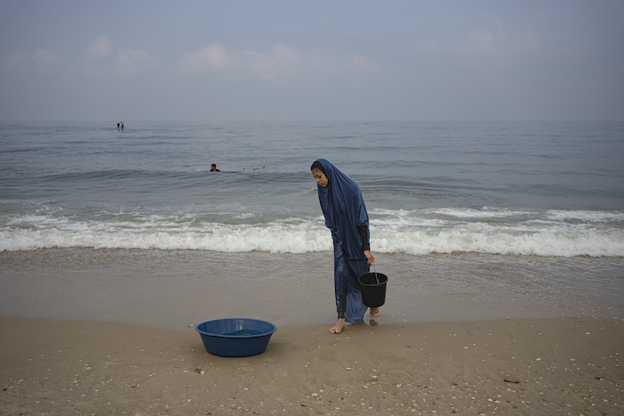 Una mujer palestina recoge agua del mar para lavar la ropa en la playa de Deir al Balah, en la Franja de Gaza, el 2 de noviembre de 2023.