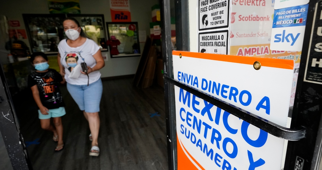 Una mujer sale de una tienda que ofrece servicios para enviar remesas a México y Centroamérica en San Diego, el 11 de septiembre de 2020.