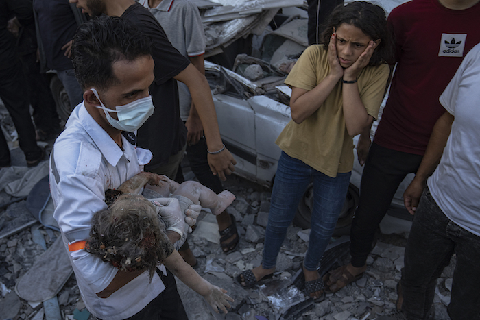 Una niña palestina reacciona al ver a un niño pequeño sacado de entre los escombros de un edificio luego de un ataque aéreo israelí sobre Jan Yunis, en la Franja de Gaza, el 21 de octubre de 2023.