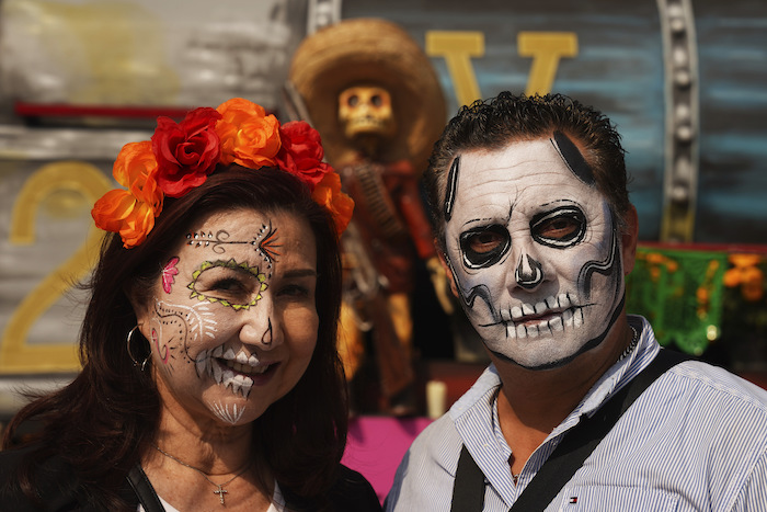 Visitantes con sus caras pintadas como catrinas posan para la foto por la celebración del Día de Muertos en el Zócalo, la principal plaza de Ciudad de México, el martes 31 de octubre de 2023.