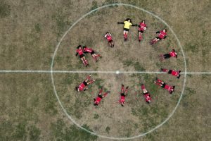 Candelaria Cabrera (arriba a la derecha) sostiene un balón, al posar junto a sus compañeras antes de un partido en Arequito, Argentina, el 19 de junio de 2023. Desde 2019, la liga regional ha ofrecido partidos para futbolistas en las categorías sub12 y sub14