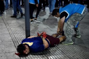 Un hincha de Boca Juniors, esposado y ensangrentado, yace de bruces luego que la policía dispersó a la multitud que se congregó en el icónico Obelisco de Buenos Aires, pese a la derrota del equipo por 2-1 ante Fluminense, el 4 de noviembre de 2023 