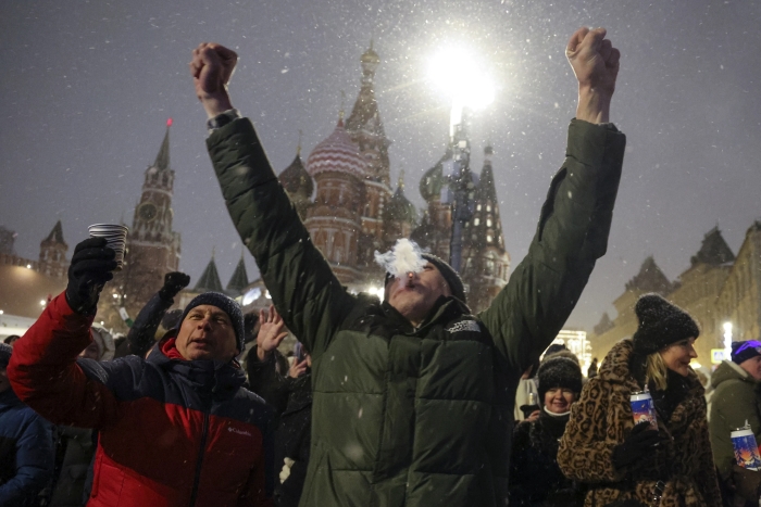 La gente se reúne cerca de la Plaza Roja con la Catedral de San Basilio, ala derecha, y la Torre Spasskaya, a la izquierda al fondo, para celebrar el año nuevo después de la medianoche en Moscú, Rusia, el lunes 1 de enero de 2024.