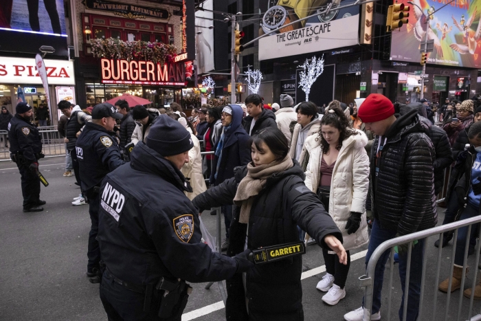 Los agentes de policía de Nueva York revisan a las personas antes de la celebración de víspera de Año Nuevo en Times Square, el domingo 31 de diciembre de 2023, en Nueva York.