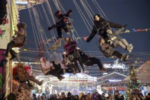 Los niños y sus padres viajan en un carrusel en un mercado navideño instalado en la Plaza Roja para el Año Nuevo y las festividades navideñas en Moscú, Rusia, el domingo 31 de diciembre de 2023.