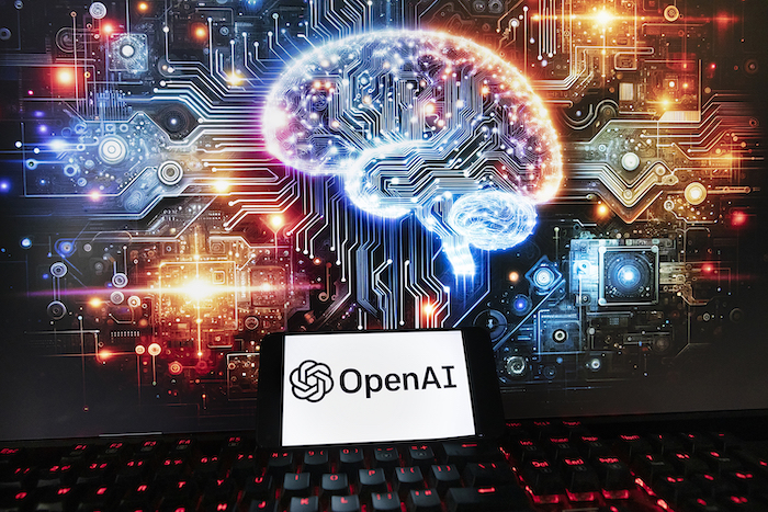 El logo de OpenAI aparece en un celular delante de una pantalla de computadora que muestra una imagen generada por el programa de conversión de texto a imagen Dall-E de ChatGPT, el viernes 8 de diciembre de 2023, en Boston.