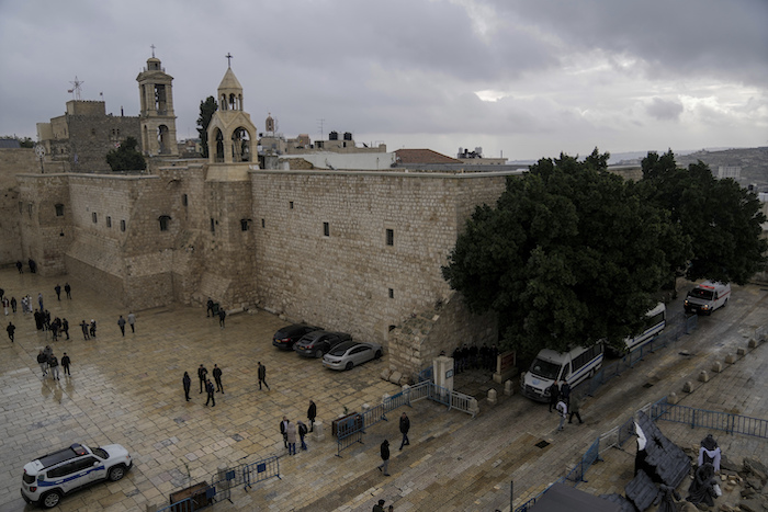 Gente camina junto a la iglesia de la Natividad, en el lugar donde según la tradición nació Jesús en Nochebuena, en la ciudad cisjordana de Belén, el domingo 24 de diciembre de 2023.