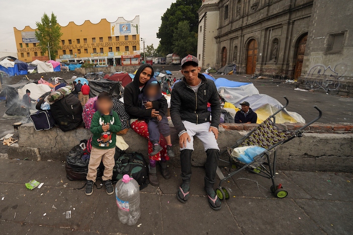 La familia Aguilar Bastida, procedente de Venezuela, fuera de la iglesia de la Santa Cruz y La Soledad, en donde algunos migrantes acampan, el martes 26 de diciembre de 2023, en Ciudad de México.