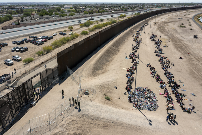 Migrantes forman filas frente a la valla en la frontera de Estados Unidos con México a la espera de ser transportados a una instalación de la Patrulla Fronteriza, el 10 de mayo de 2023, en El Paso, Texas.