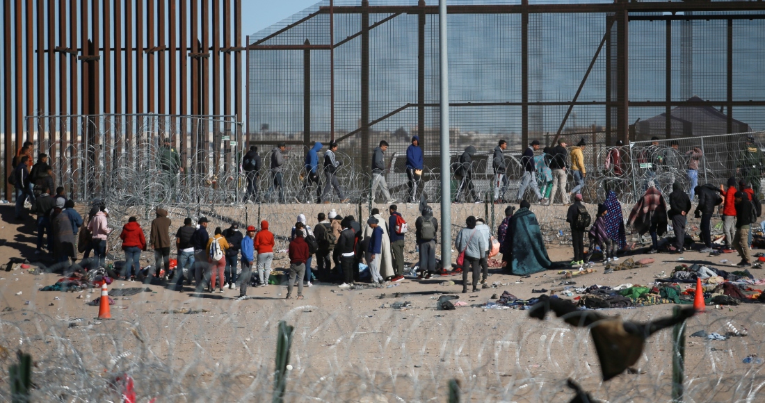 Migrantes formados después de ser detenidos por las autoridades migratorias de Estados Unidos en el muro fronterizo, el miércoles 27 de diciembre de 2023. Foto: Christian Chavez, AP